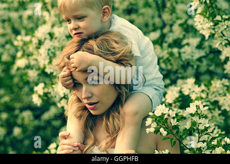 Caucasian mother holding fils près de l'arbre en fleurs Banque D'Images