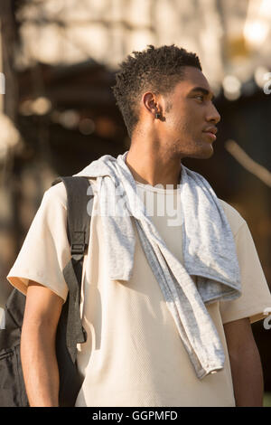 Mixed Race man avec sac à dos et shirt drapé sur les épaules Banque D'Images