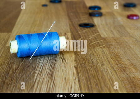 Vieux outils de couture sur le fond de bois : tiroirs, aiguilles, boutons. Composition horizontale. Banque D'Images