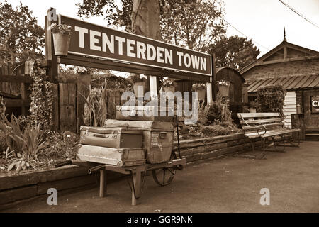 Image sépia d'anciens cas de voyage sur panier sur la plate-forme de la gare Ashford, Kent et l'East Sussex Railway. Banque D'Images