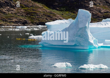 Les touristes kayak à proximité de grands Icebergs de fjord Tunulliarfik en été. , Narsaq Kujalleq, Sud du Groenland Banque D'Images