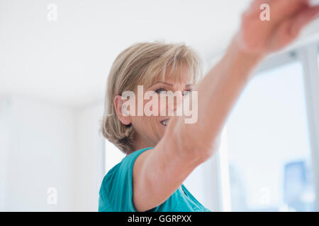 Older Caucasian woman with arms outstretched Banque D'Images