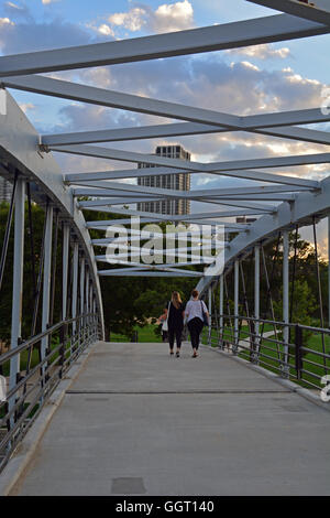 Deux jeunes femmes à pied à travers la passerelle au-dessus de Lake Shore Drive menant de Lincoln Park au nord Avenue Beach. Banque D'Images