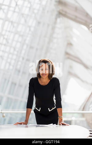 Black businesswoman leaning over paperwork salle de conférence Banque D'Images
