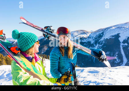 Des femmes portant des skis en montagne enneigée Banque D'Images