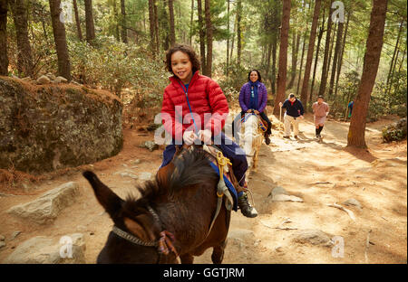 Mixed Race mother and son riding horses Banque D'Images