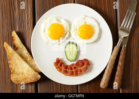 Funny face servant le petit-déjeuner, œuf frit et toasts Banque D'Images