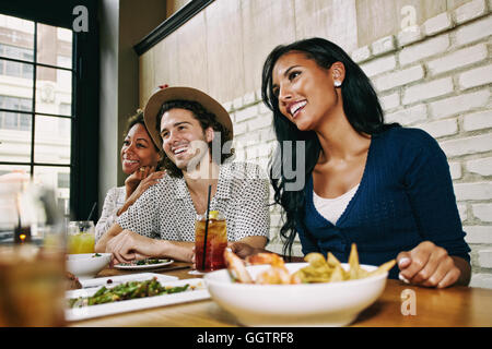 Smiling friends vous restaurant et des cocktails au bar de la table Banque D'Images