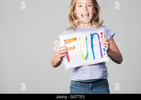 Happy Mixed Race girl holding fun sign Banque D'Images