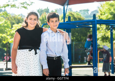 Fier bien habillés Mixed Race brother and sister posing on playground Banque D'Images