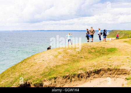 Kaseberga, Suède - août 1, 2016 : les touristes debout sur la colline de sable couverte d'herbe surplombant la vue sur la mer ci-dessous. Coastlin Banque D'Images