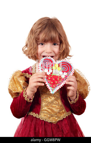 Little girl eating gingerbread heart Banque D'Images