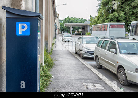 Un parcomètre ou ticket station paye avec des voitures sur la route dans l'arrière-plan flou. Banque D'Images