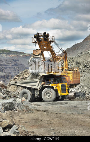 L'extraction de minerai de fer - excavateur est le camion benne de chargement sur l'exploitation à ciel ouvert Banque D'Images