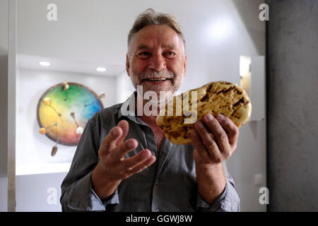 Kazimieras Mizgiris propriétaire du musée de la galerie Amber posant avec un morceau de pierre ambrée non polie dans sa galerie dans la ville de Nida en Lituanie. La région de la Baltique abrite le plus grand gisement connu d'ambre. Il date d'il y a 44 millions d'années et inclut la faune d'insectes fossiles la plus riche en espèces découverte à ce jour. Banque D'Images