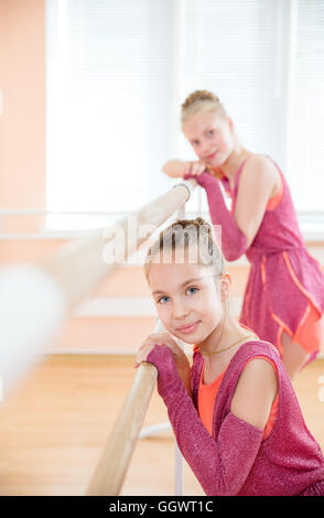 Les jeunes ballerines reposant à barre en classe de ballet Banque D'Images