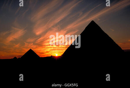 Coucher de soleil derrière les grandes pyramides de Gizeh. Le Caire - Egypte. Banque D'Images