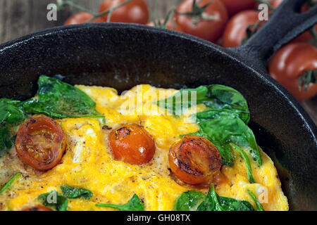 Frittata aux épinards avec tomate cerise dans iron skillet Banque D'Images