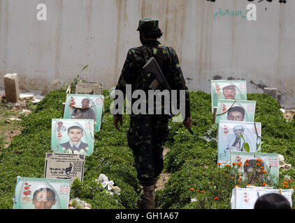 Sanaa, Yémen. 7e août 2016. Un homme marche entre les tombes des combattants Houthi tués dans les frappes aériennes par la coalition menée par l'Arabie Saoudite, à un cimetière à Sanaa, capitale du Yémen, le 7 août 2016. Credit : Hani Ali/Xinhua/Alamy Live News Banque D'Images