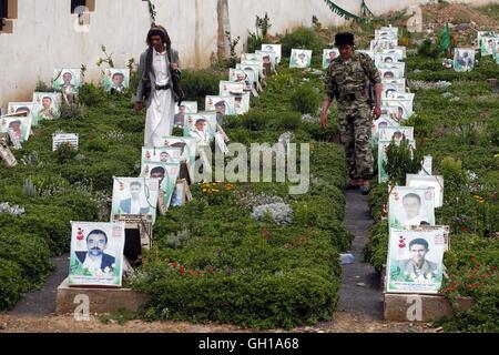 Sanaa, Yémen. 7e août 2016. On marche entre les tombes des combattants Houthi tués dans les frappes aériennes par la coalition menée par l'Arabie Saoudite, à un cimetière à Sanaa, capitale du Yémen, le 7 août 2016. Credit : Hani Ali/Xinhua/Alamy Live News Banque D'Images