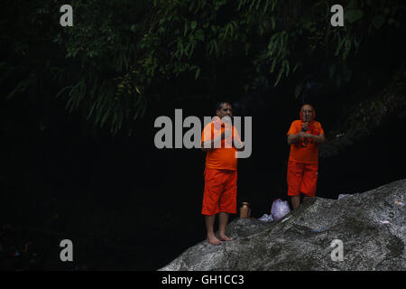 Katmandou, Népal. 8e août 2016. Les fidèles hindous ou pèlerins, également connu sous le bol de Bom offrir des prières après la prise d'un bain dans la rivière Bagmati saint pour adorer le Seigneur Shiva au cours de la mois sacré hindou de l'Shrawan festival Sombar ou Bol Bom pèlerinage à Sundarijal à Katmandou, au Népal, le lundi, 8 août, 16. Pèlerins du Népal et l'Inde billet d'environ 22 kilomètres à pieds nus de Sundarijal Katmandou la ville de recueillir de l'eau bénite et retourner à Pashupathinath Temple pour offrir le culte à dieu hindou Shiva. Le festival dure un mois, au cours de laquelle la foule de dévots au temple alors que le jeûne Banque D'Images