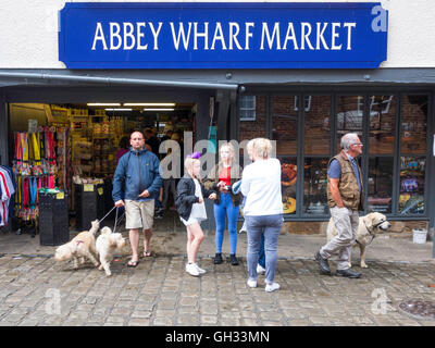 Groupe familial avec des chiens à l'extérieur de l'abbaye Place du Marché Marché quai à Whitby, North Yorkshire Banque D'Images