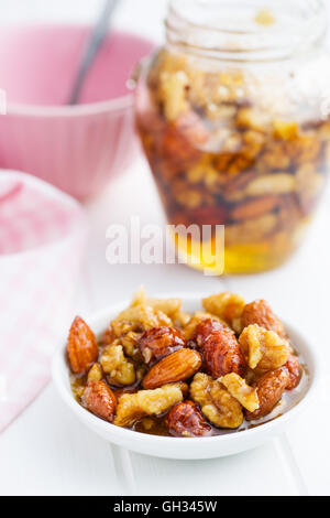 Le miel et les noix dans un bol sur une table de cuisine. Banque D'Images