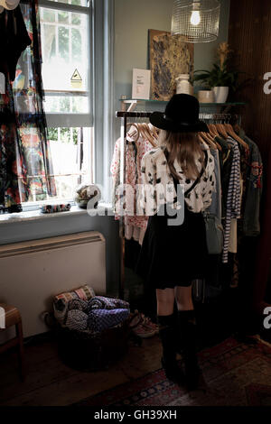 A 12 ans, fille, portant un chapeau noir dans un magasin de vêtements vintage parcourt Banque D'Images