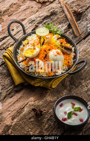 Riz Basmati cuit lentement avec Masala oeuf et épices servi dans kadhai ou kadai avec une trempette au yogourt, selective focus Banque D'Images