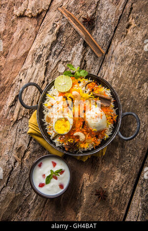 Riz Basmati cuit lentement avec Masala oeuf et épices servi dans kadhai ou kadai avec une trempette au yogourt, selective focus Banque D'Images