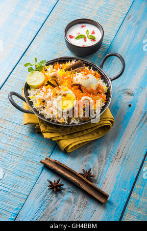 Riz Basmati cuit lentement avec Masala oeuf et épices servi dans kadhai ou kadai avec une trempette au yogourt, selective focus Banque D'Images