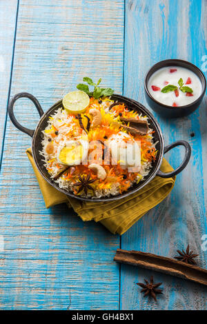 Riz Basmati cuit lentement avec Masala oeuf et épices servi dans kadhai ou kadai avec une trempette au yogourt, selective focus Banque D'Images