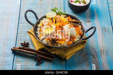 Riz Basmati cuit lentement avec Masala oeuf et épices servi dans kadhai ou kadai avec une trempette au yogourt, selective focus Banque D'Images