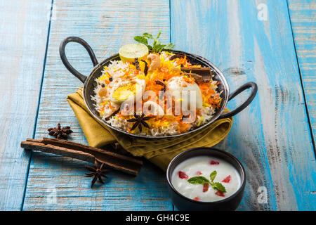 Riz Basmati cuit lentement avec Masala oeuf et épices servi dans kadhai ou kadai avec une trempette au yogourt, selective focus Banque D'Images