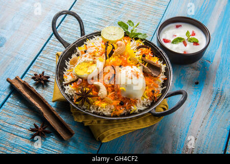 Riz Basmati cuit lentement avec Masala oeuf et épices servi dans kadhai ou kadai avec une trempette au yogourt, selective focus Banque D'Images