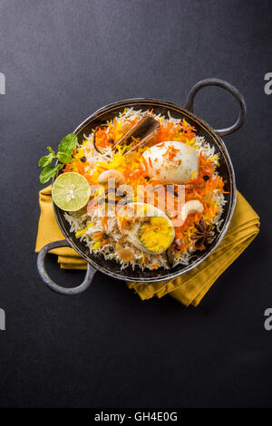 Riz Basmati cuit lentement avec Masala oeuf et épices servi dans kadhai ou kadai avec une trempette au yogourt, selective focus Banque D'Images