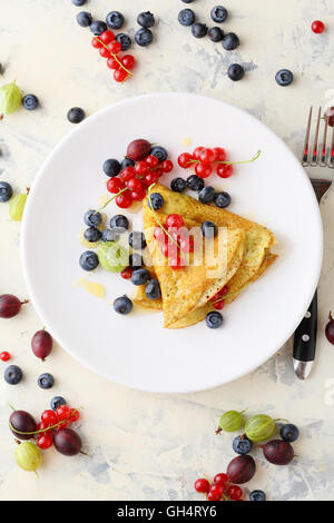 Crêpe aux fruits rouges d'été sur plaque blanche. Au-dessus de l'alimentation Banque D'Images