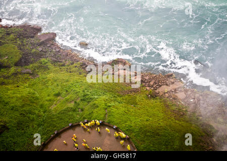 Les touristes portant des ponchos jaunes donnent à la tombe d'une plate-forme de niveau d'eau à Niagara Falls, Canada. Banque D'Images