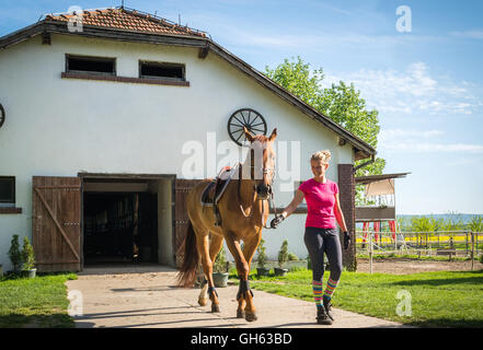 Fille à cheval en stable Banque D'Images