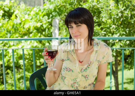 Femme buvant du vin rouge dans un vignoble, piscine Banque D'Images