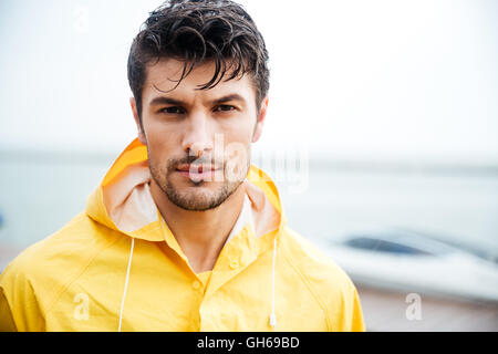 Portrait d'un beau jeune homme en manteau jaune de marin Banque D'Images