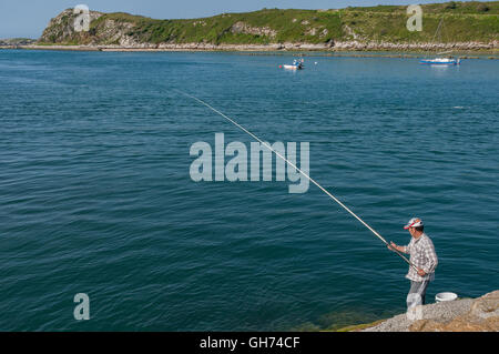 L'homme pêche sur la digue de la Saja et Besaya ria, dans le village de Suances Cantabria, Espagne. Banque D'Images