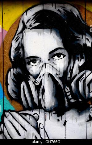 Street Art photo murale graffiti de femme portant un masque à gaz oxygène London England Banque D'Images