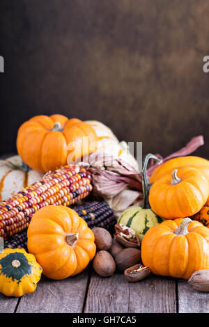 Variété de citrouilles décoratives colorées sur une table Banque D'Images