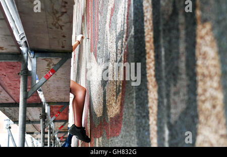 Dresde, Allemagne. 4e août 2016. Les étudiants travaillant sur la fresque "Der Weg der Roten Fahne' (lit. 'La voie du drapeau rouge) à la façade occidentale de l'Kulturpalast à Dresde, Allemagne, 4 août 2016. Depuis 2001, la murale compte comme un monument culturel. PHOTO : JENS KALAENE/dpa/Alamy Live News Banque D'Images