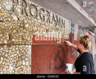 Dresde, Allemagne. 4e août 2016. Les étudiants travaillant sur la fresque "Der Weg der Roten Fahne' (lit. 'La voie du drapeau rouge) à la façade occidentale de l'Kulturpalast à Dresde, Allemagne, 4 août 2016. Depuis 2001, la murale compte comme un monument culturel. PHOTO : JENS KALAENE/dpa/Alamy Live News Banque D'Images