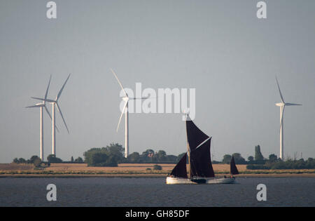 West Mersea, Essex, Royaume-Uni. 9 août 2016. Météo France : une barge de la Tamise voiles cours des éoliennes de Bradwell sur la rivière Blackwater, tôt ce matin. Crédit : Andrew O'Brien/Alamy Live News Banque D'Images