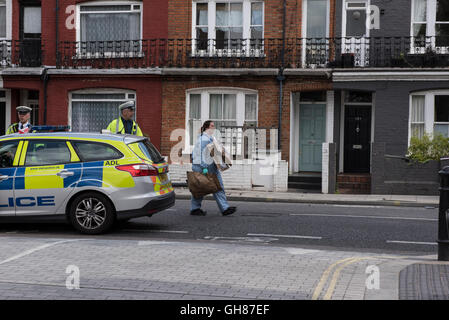 Londres, Royaume-Uni. 9 Août, 2016. Recueil des preuves sur les lieux du crime sur Wandsworth Bridge Road après fatal du CCF. La police a été la poursuite du véhicule après des rapports faisant état d'un drone en vol près de la prison de Wandsworth à Londres. L'un des occupants de la voiture, une femme dans la vingtaine, a été déclaré mort sur les lieux. L'autre occupant de la voiture, le conducteur, un homme que l'on croit être vieilli dans son 20s, a été conduit à un hôpital de l'ouest de Londres. Crédit : Peter Manning/Alamy Live News Banque D'Images