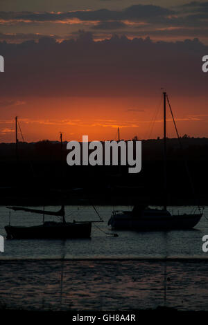 West Mersea, Essex, Royaume-Uni. 9 Août, 2016. Météo France : Le soleil se couche derrière les yachts au mouillage dans West Mersea sur la rivière Blackwater dans l'Essex. Andrew O'Brien/Alamy Live News Banque D'Images