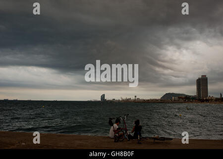 Barcelone, Espagne - 09 août 2016. Les gens est vu la jetée en face de la mer Méditerranée comme nuages dans le ciel avant un orage d'été dans la ville de Barcelone. Crédit : Jordi Boixareu/Alamy Live News Banque D'Images